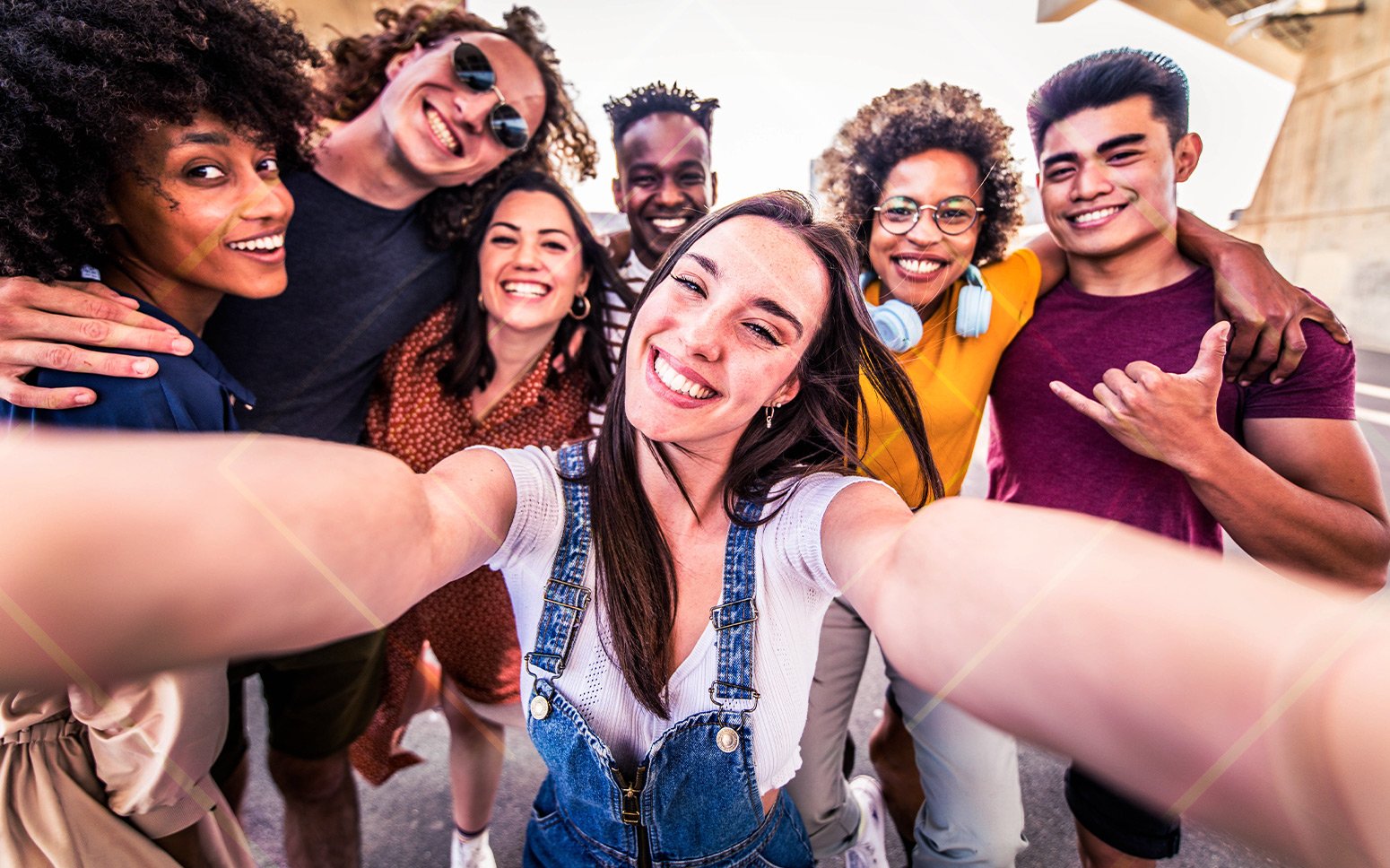 A group of Gen Z retail consumers take selfie, smiling into camera. 